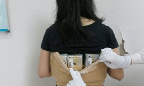Kaçakçı kadın vücuduna sarılı 102 İPhone ile yakalandı